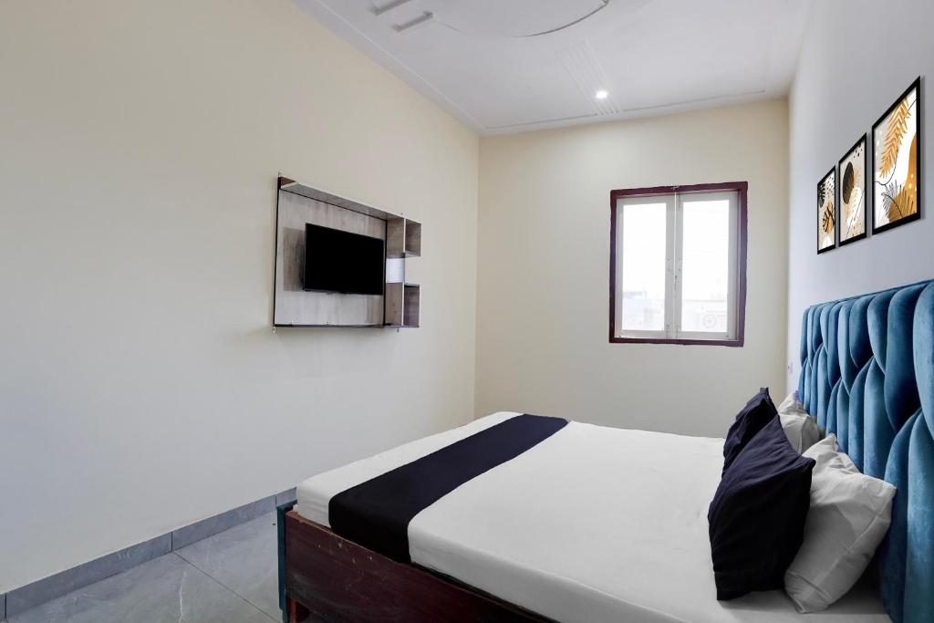 a bedroom with a bed and a tv on the wall at Hotel O The Signature Residency in Rohtak
