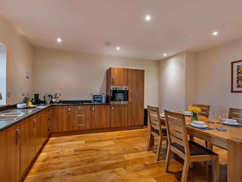 a kitchen with wooden cabinets and a table with chairs at 2 Bed in Bishop Auckland oc-94321 in Wolsingham