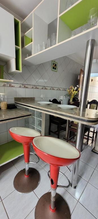 a kitchen with two red stools in a kitchen at Casa grande com suite in São Luís