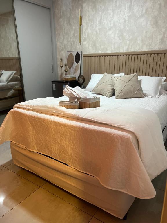 a large bed with a blanket on it in a bedroom at Flat 701 in Guarulhos