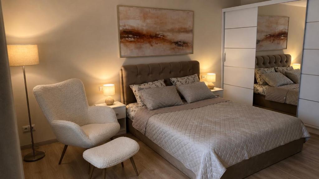 a bedroom with a bed and a chair and a mirror at Apartamentai Tarp 7 Ežerų in Zarasai
