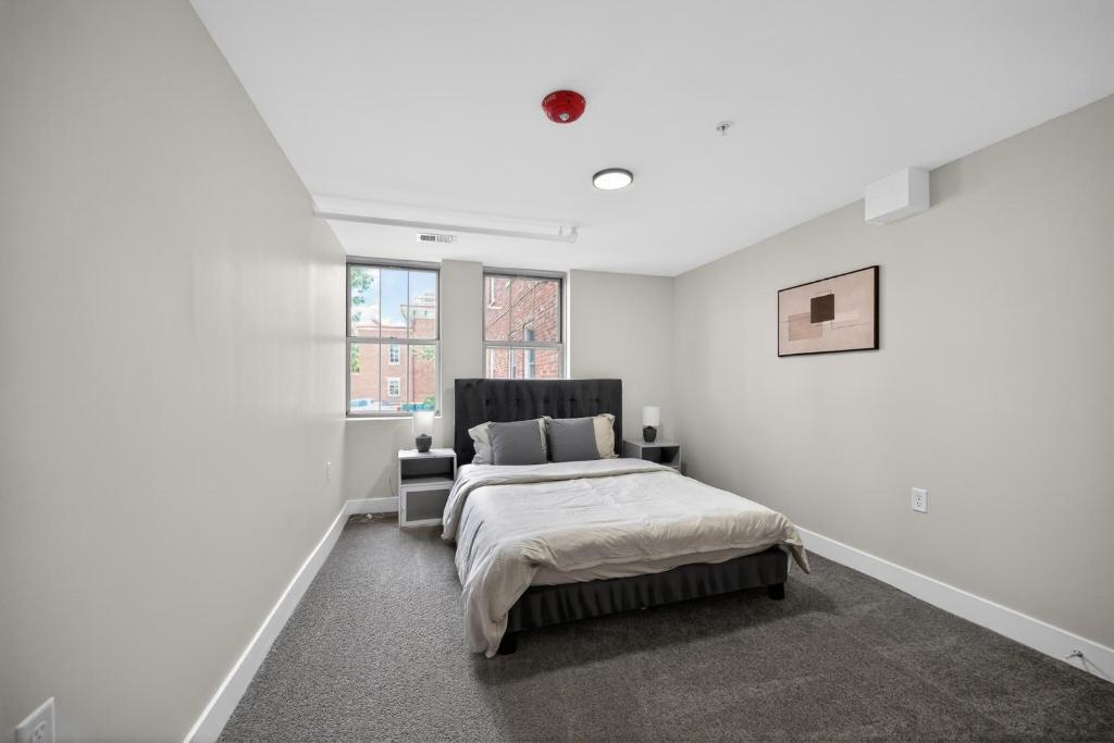 a white bedroom with a bed and a window at Sleek 2BR apartment in prime location in Reading