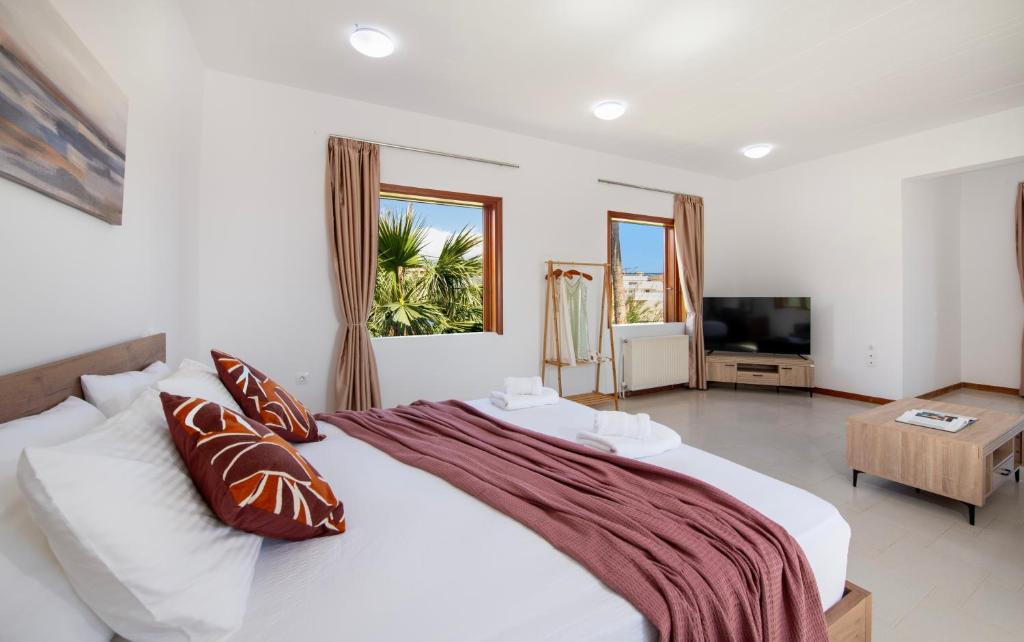 a bedroom with a large white bed and a television at Fiore Marino in Kamisianá