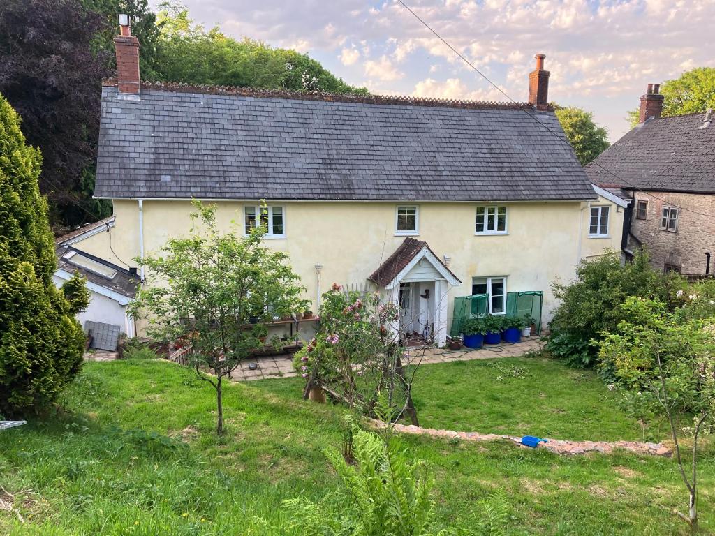 a white house with a black roof at Watercombe House in Wheddon Cross