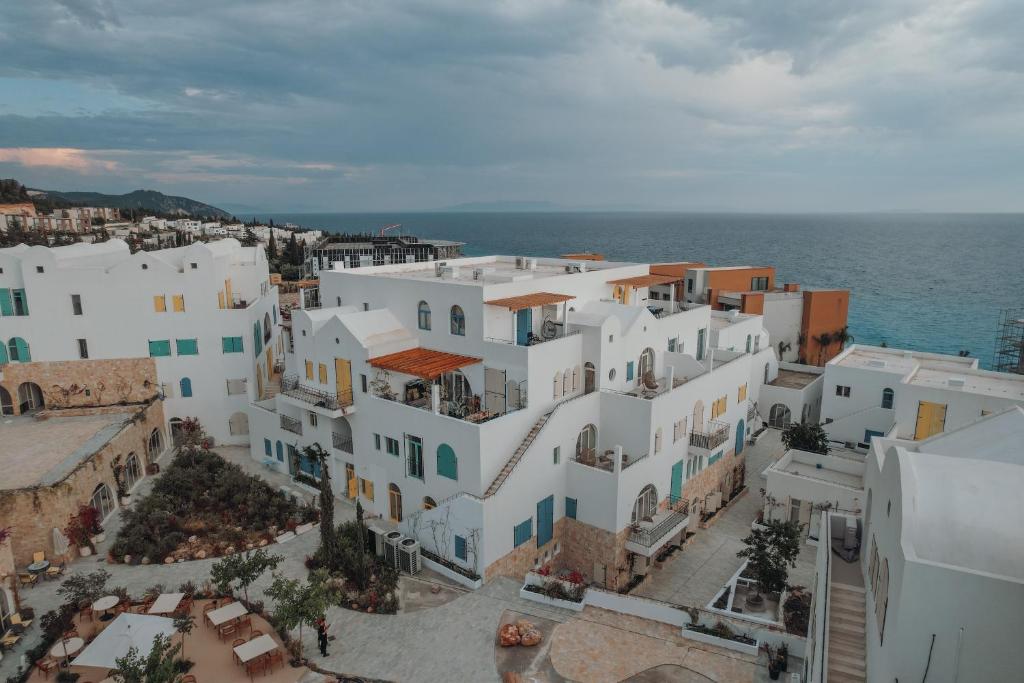 an aerial view of a town with white buildings and the ocean at IONEO Dhermi in Dhërmi