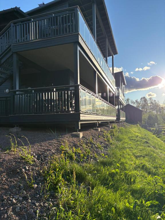 a house with a balcony on a grassy hill at Panorama 3 Kungsberget in Järbo