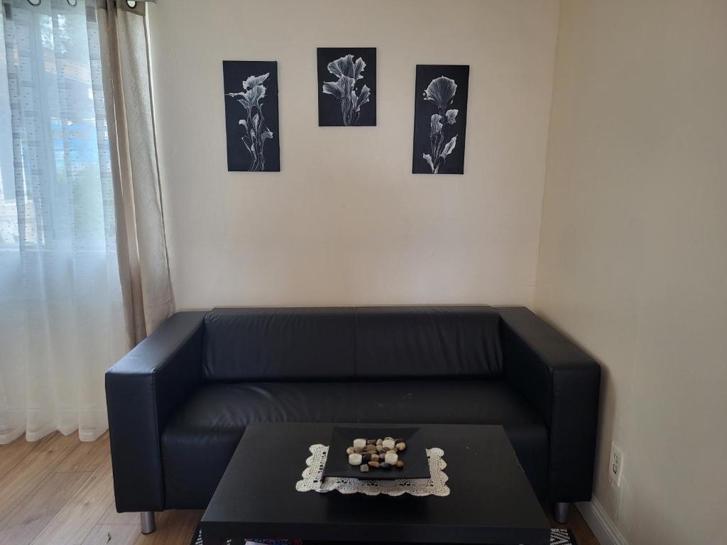 a black leather couch in a living room with a table at Guest house in Tujunga