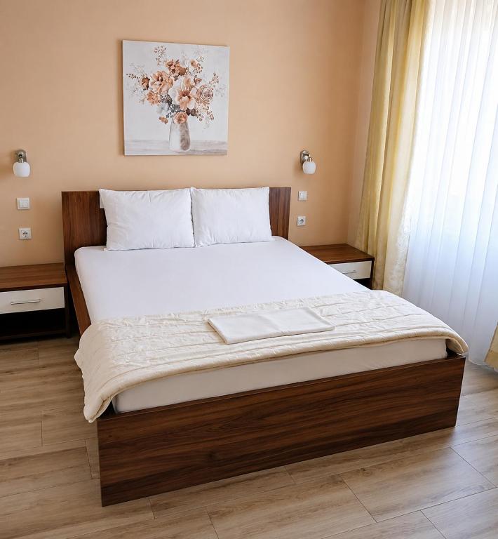 a bedroom with a large bed with white sheets at Apartmani Medijana Niš in Niš