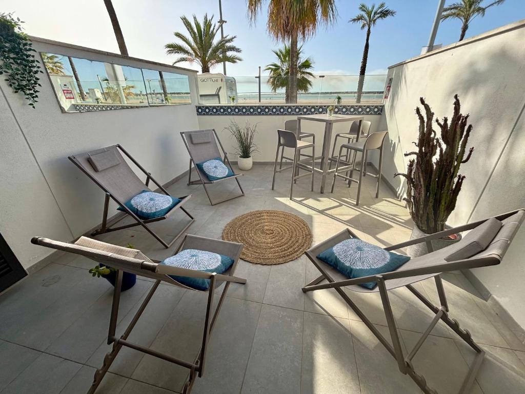 a patio with chairs and a table on a balcony at Arenas de Sanlúcar in Sanlúcar de Barrameda