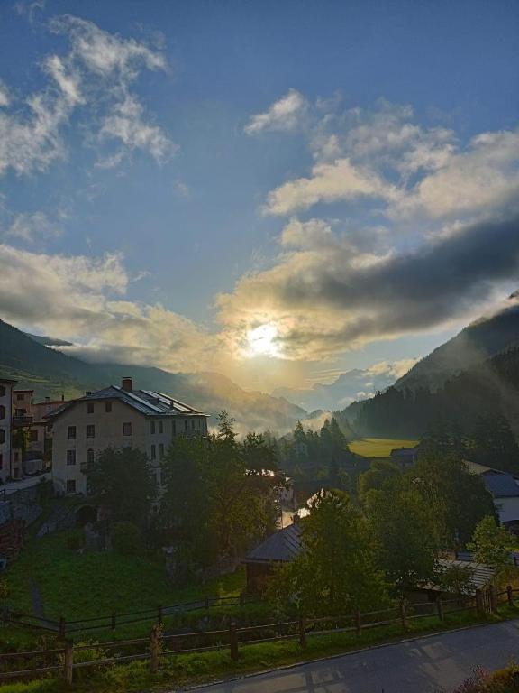 a view of a town with the sun setting in the mountains at Im Laret, Lavin in Zernez