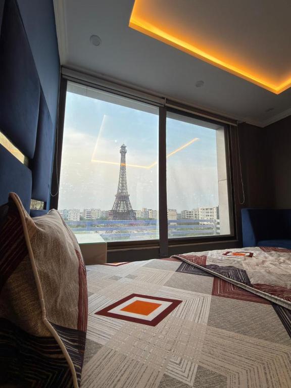 a bedroom with a view of the eiffel tower at Maison Eleve Residency in Lahore