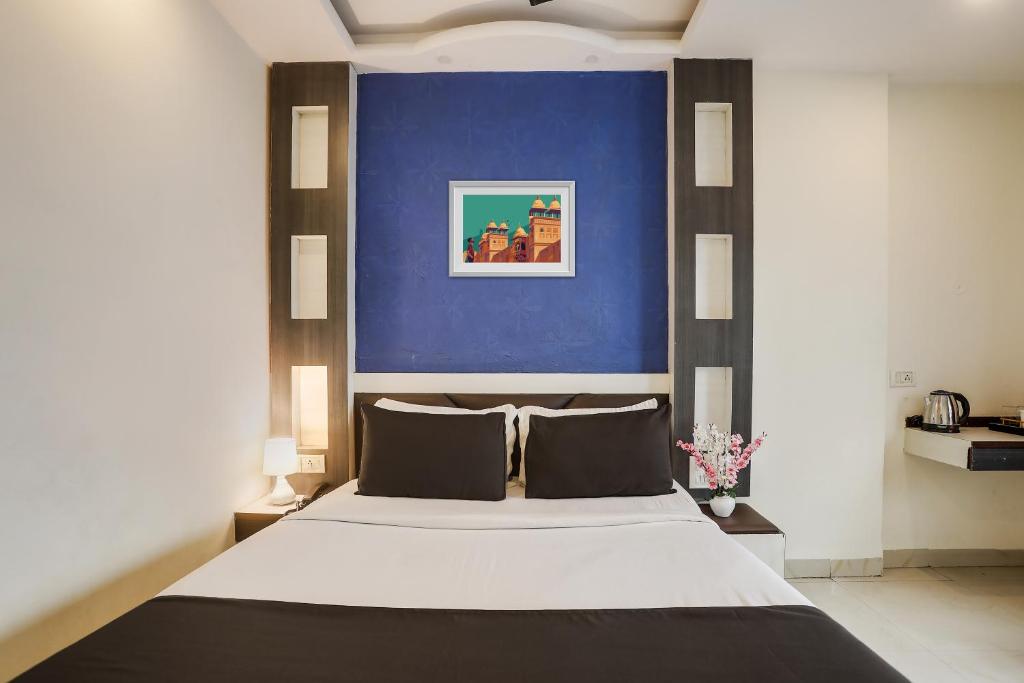 a bedroom with a large bed with a blue wall at Super Capital O Prestige in Hyderabad