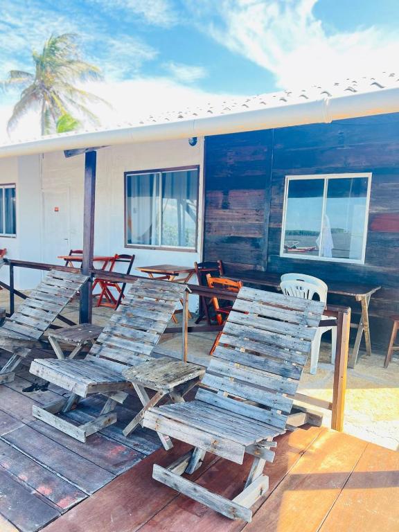 a deck with lounge chairs and a table and a house at Chalé Mar Aberto in Atins
