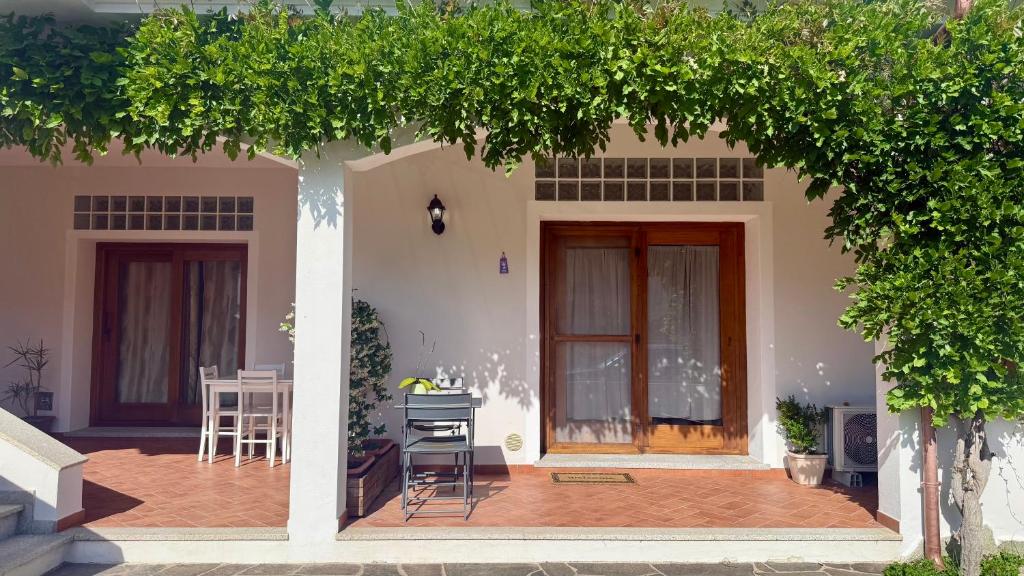 a house with a porch with a table and a chair at Luciana House in Olbia