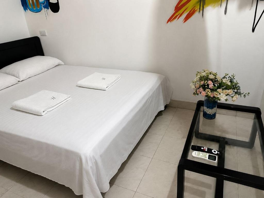 a room with a bed and a table with flowers at Casa hostal la herradura in San Vicente de Chucurí