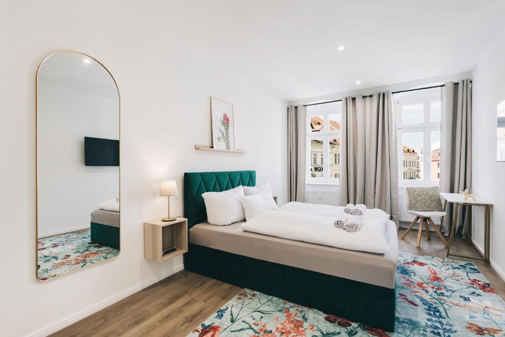 a bedroom with a bed and a mirror at Altmarkt Palais in Löbau