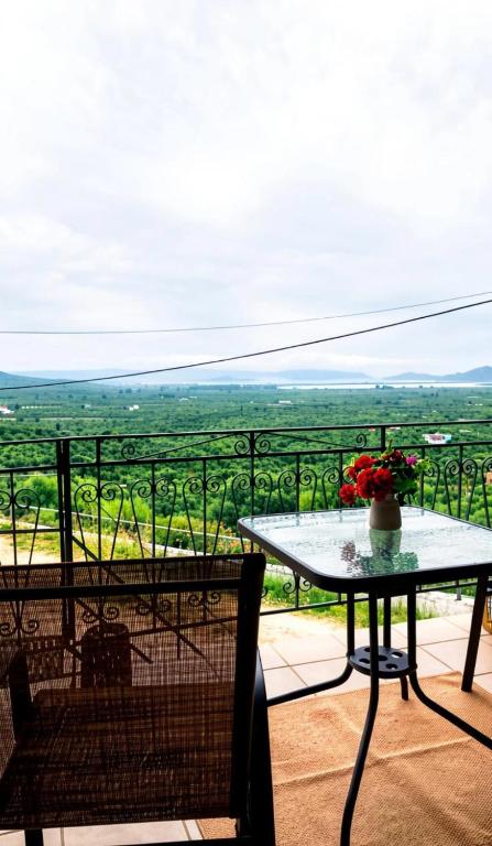 Ein Tisch und Stühle auf einem Balkon mit Aussicht in der Unterkunft Dinis Hill in Tragána