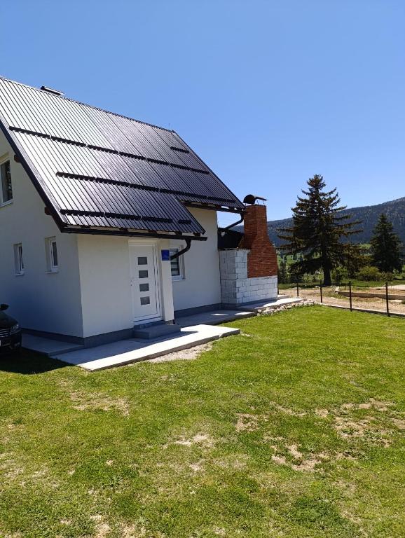 a house with a solar roof on top of a yard at Vikendica Nuhanović - Vlašić in Vlasic