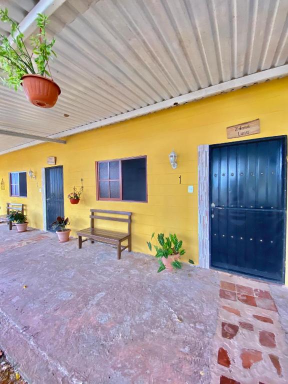 a yellow wall with a bench in front of a building at Hotel Shalva Barahona in Izamal