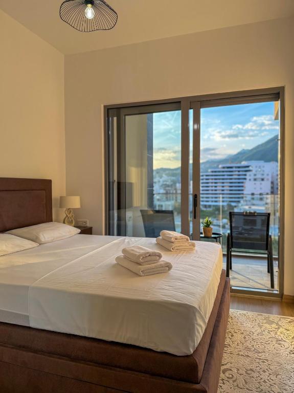 a bedroom with a bed with two towels on it at JoHa Stay in Bar