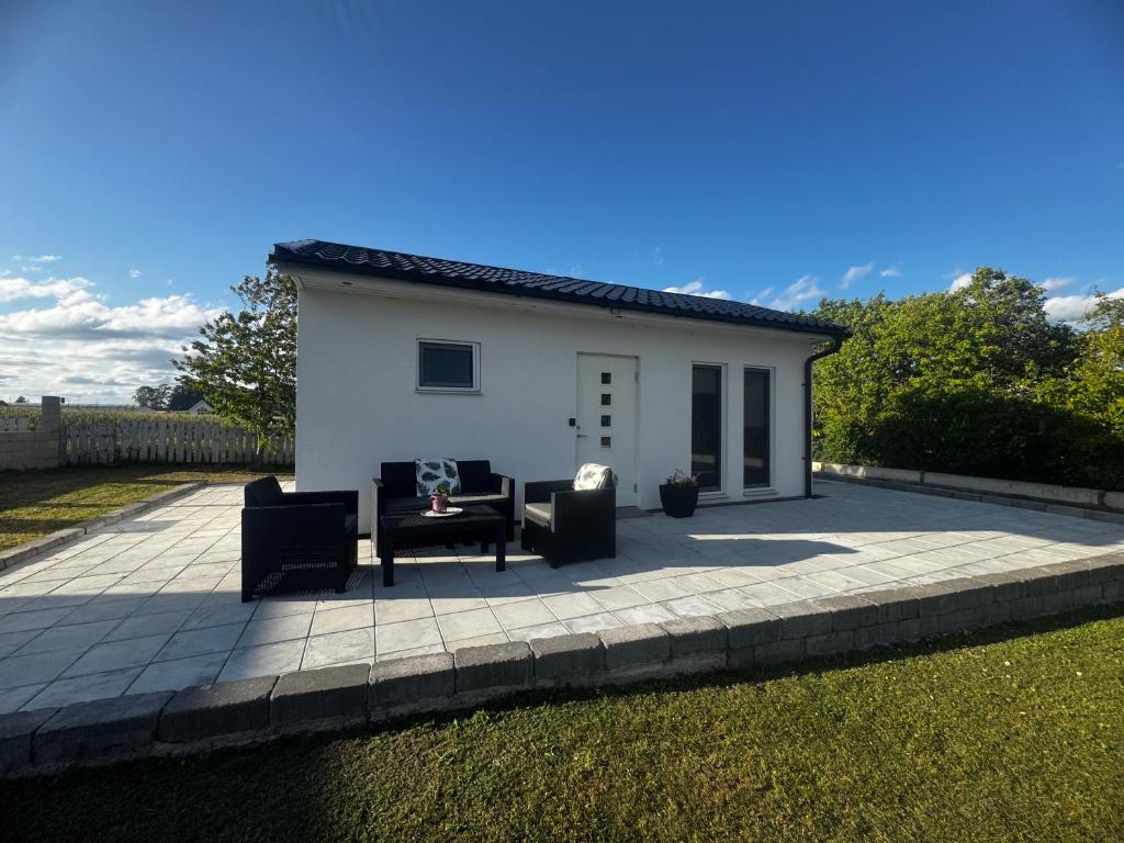 a small white house with two couches on a patio at Hammar Hus in Kristianstad