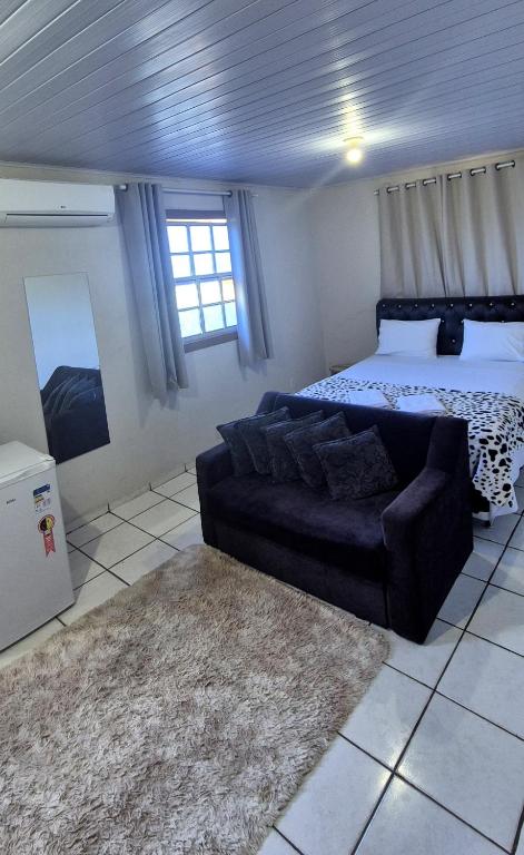 a living room with a couch and a bed at Pousada chafariz in Pirenópolis