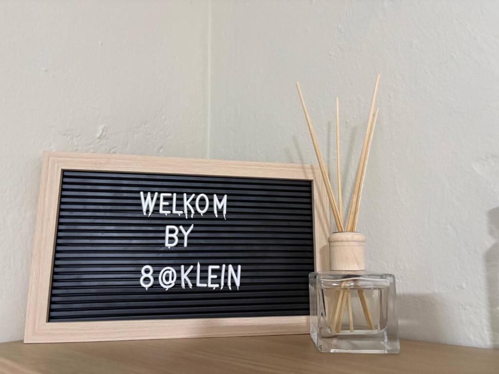 a sign that says wisdom by eight eighteen next to a vase at Accommodation at Klein Street-Blue in Paarl