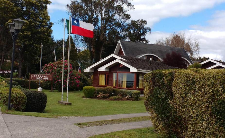 a house with a flag in front of it at Cabañas Lago Sur in Puerto Varas