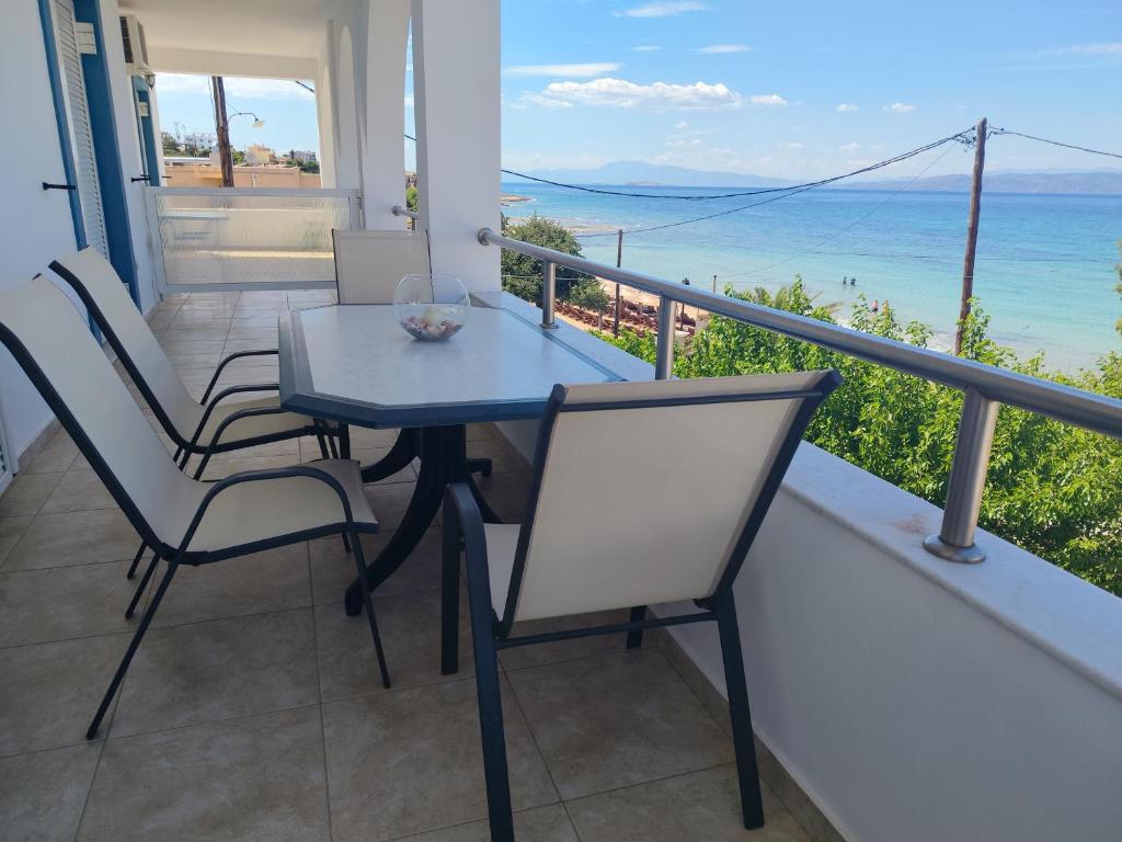 a table and chairs on a balcony with the ocean at Adam s house in Vaia