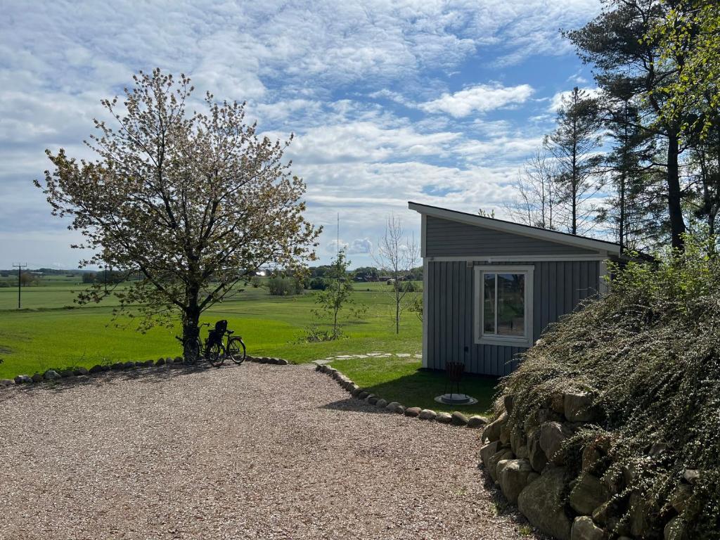 a small shed with a bike parked next to a tree at The Fäxaåsen cabin in Varberg