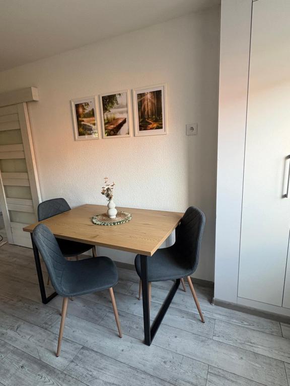 a wooden table with chairs and a vase on it at Apartmán Olive in Terchová