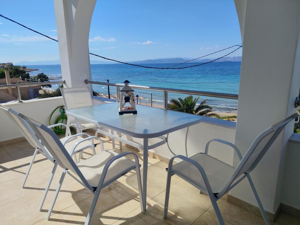 a table and chairs on a balcony with the ocean at Marinas house in Vaia