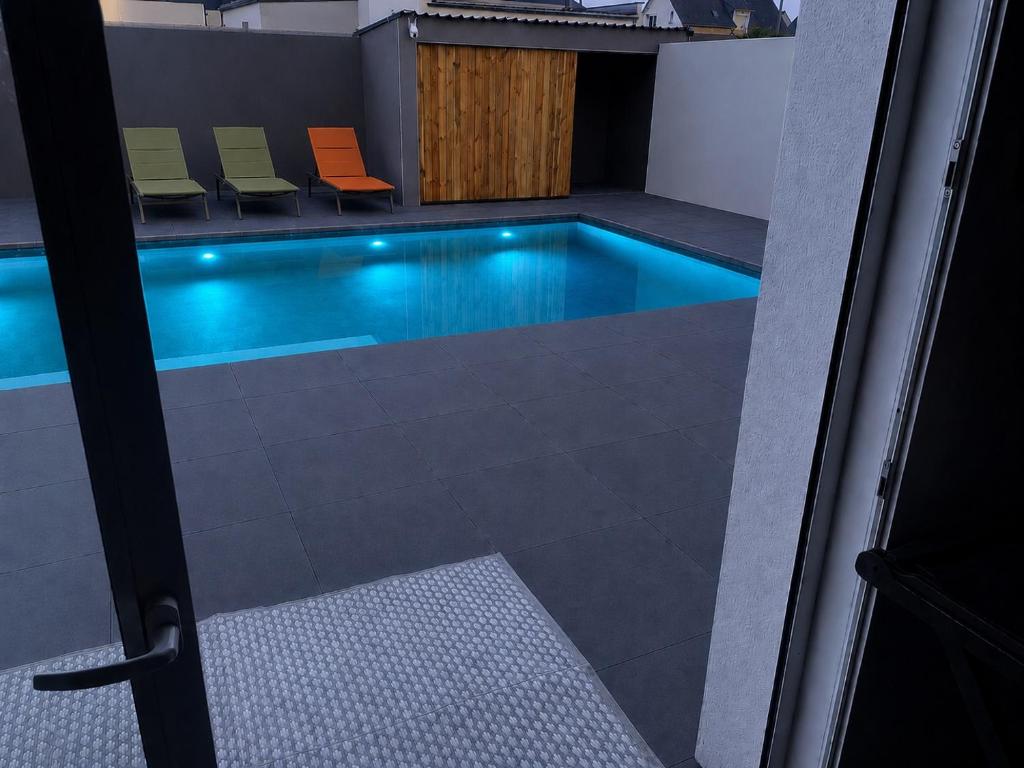 a swimming pool with chairs in a building at Silver in Quessoy