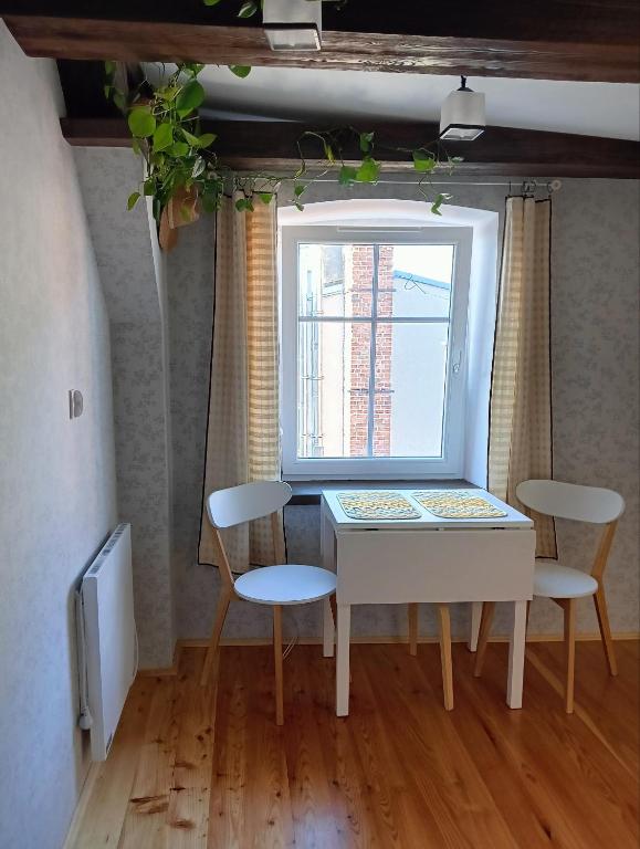 a table and chairs in a room with a window at Craft Corner Apartment Namysłów - Rynek in Namysłów