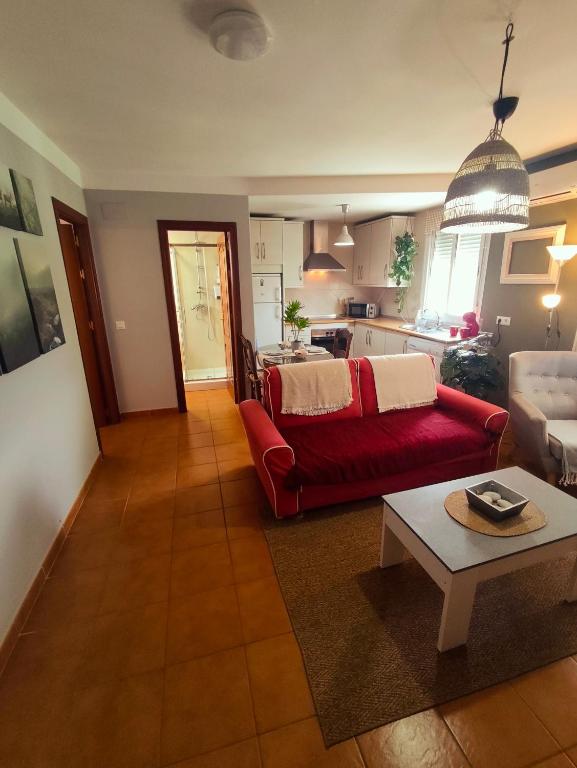 ein Wohnzimmer mit einem roten Sofa und eine Küche in der Unterkunft El Bosque NOMADA 5 in El Bosque