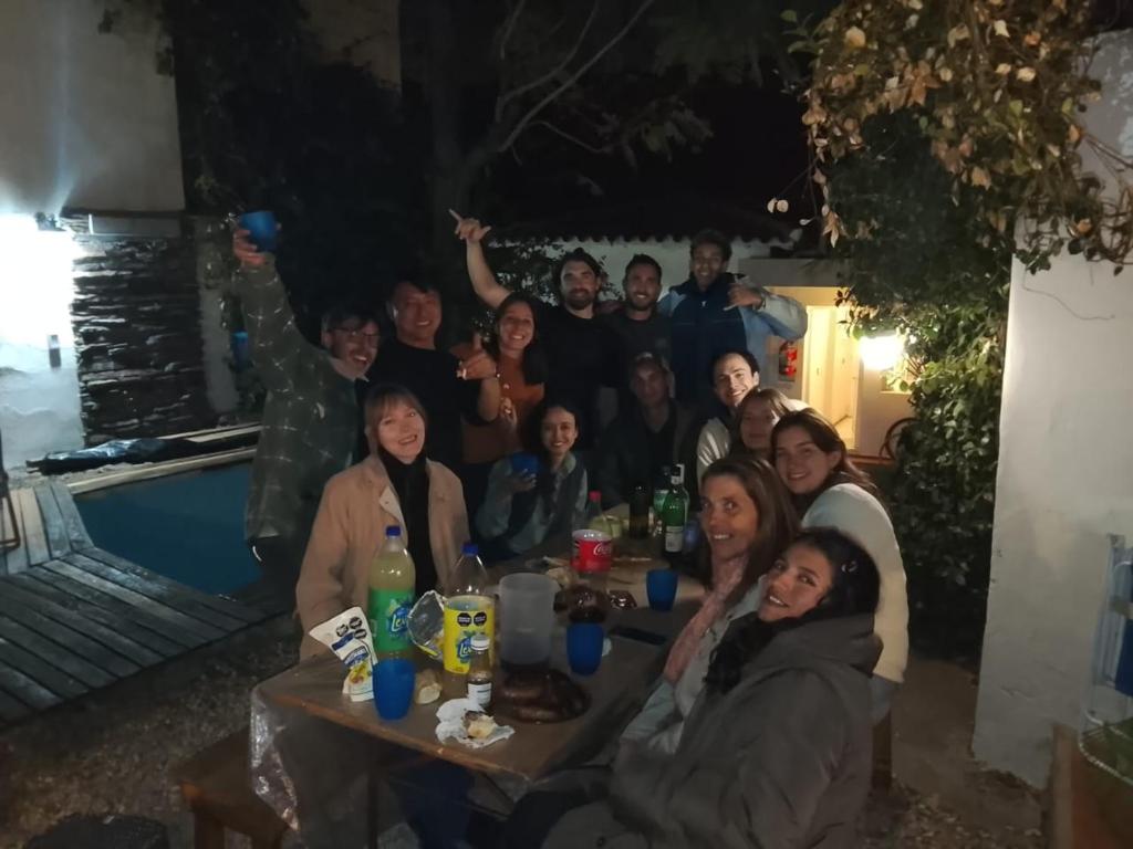 a group of people sitting at a table at night at Pulkay Hostel Folk in Mendoza