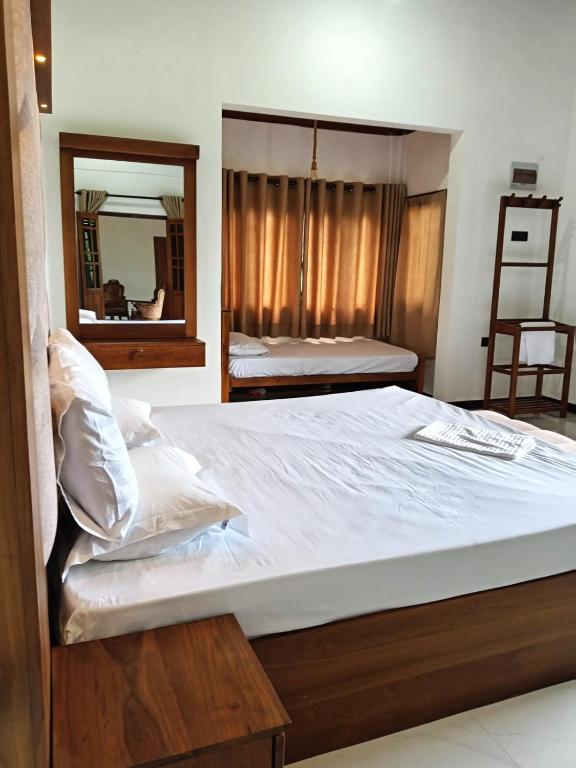 a bedroom with a large bed with a mirror at Ruwan's HomeStay in Matale
