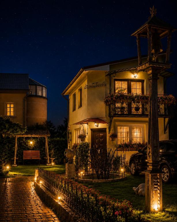a house with lights in front of it at night at Adomo Rojus in Palanga