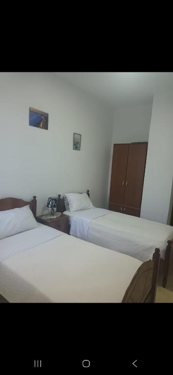 two beds sitting next to each other in a room at Vila Ameli Bucimas in Buçimas