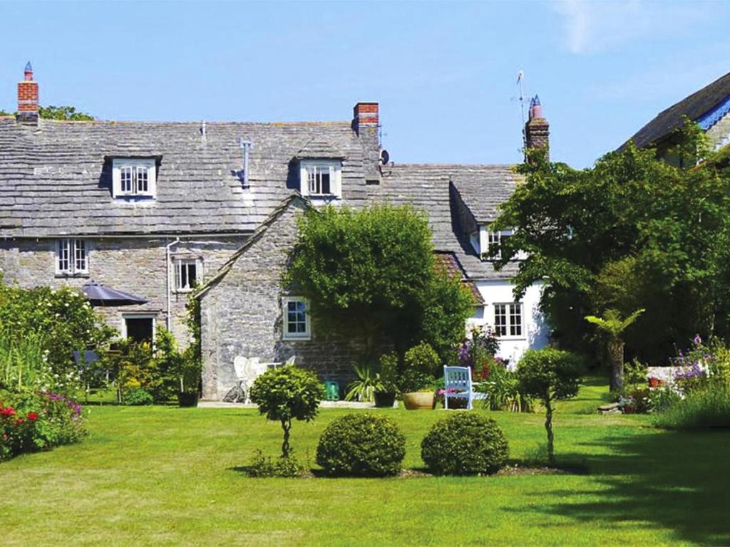 an old stone house with a yard with trees and bushes at 4 Bed in Corfe Castle oc-ic126 in Corfe Castle