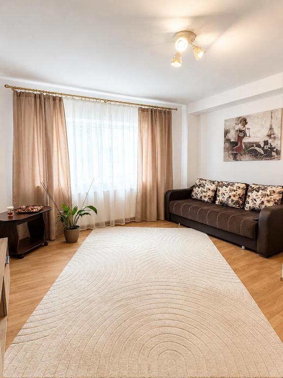 a living room with a couch and a large rug at Reyna Breeze Apartment in Constanţa