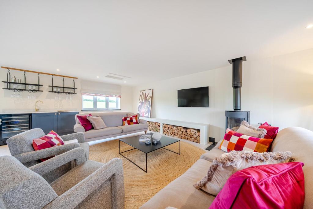 a living room with two couches and a fireplace at Bell House in Amlwch