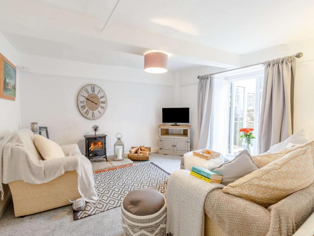 a living room with a couch and chairs and a fireplace at 3 Bed in Cullompton oc-85389 in Willand