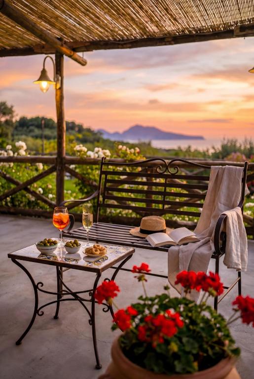 eine Terrasse mit einem Tisch, Weingläsern und Blumen in der Unterkunft Villa Lorelei in Massa Lubrense
