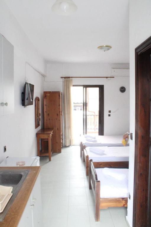 a room with four beds and a sink in it at Solis Apartments in Kallithea Halkidikis