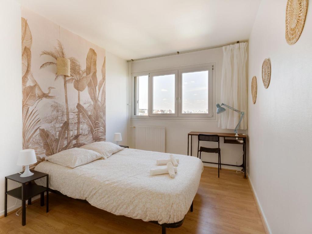 a bedroom with a large bed and a desk at Vue sur Paris, Centre Ville in Choisy-le-Roi