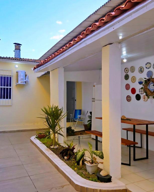 a house with a patio with a table and chairs at Home Hostel Maceió in Maceió