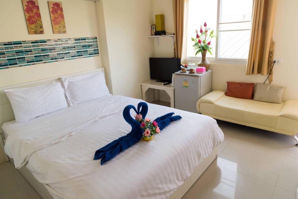 una camera da letto con un letto con un nastro blu sopra di Lotus Suite Hua Hin a Hua Hin