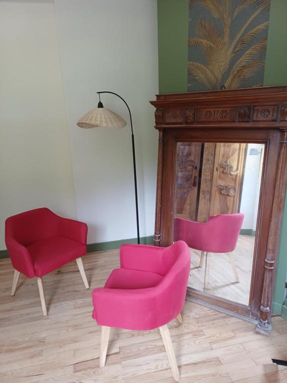 a room with two pink chairs and a mirror at OAK Familly in Saint-Racho