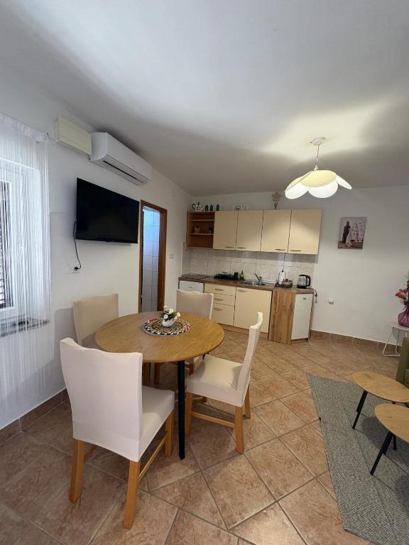 a kitchen and dining room with a table and chairs at Apartman Velina in Pakoštane